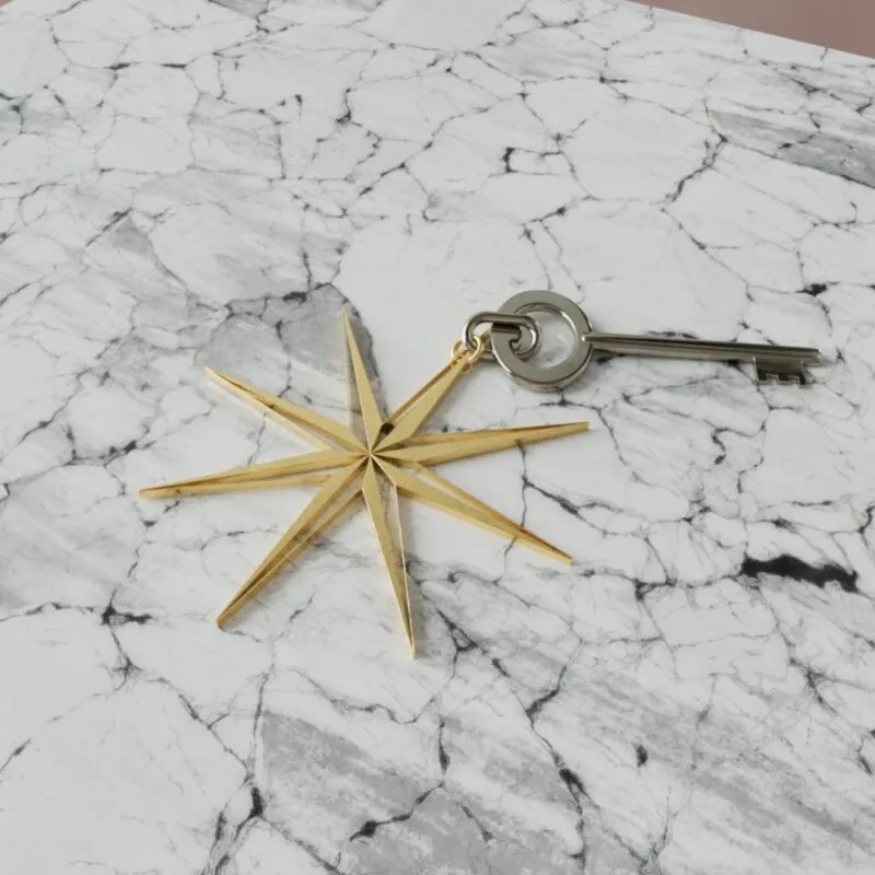Luxury travel book custom made key ring of compass logo on marble surface